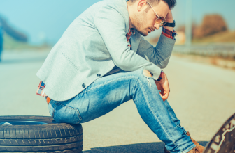 Homme assis sur un pneu au bord de la route, pensif, avec une expression de réflexion et de fatigue, symbolisant les défis personnels ou la gestion du stress dans un contexte quotidien.