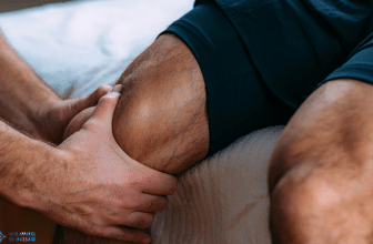 Une personne effectue un massage du genou sur un homme assis, en exerçant une pression douce avec les deux mains autour de l'articulation.